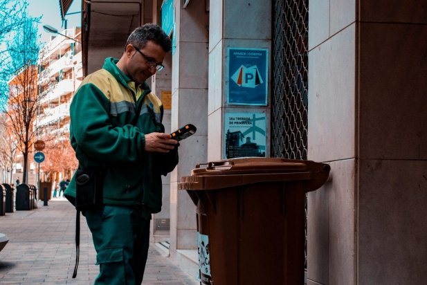 Un operari de FCC davant d'un contenidor de matèria orgànica dimecres a la tarda al carrer Montcada_617x412