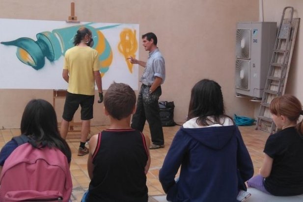 Weren's durant l'elaboració del seu grafit al costat d'Enric Aguilar i els seus alumnes_617x412