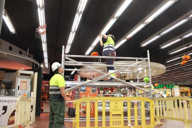 Operaris de la brigada col·locant fluorescents led al Mercat aquest matí_617x412