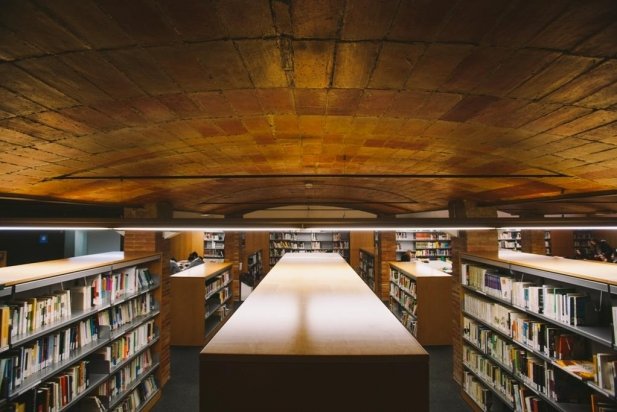Una imatge de l'interior de la planta baixa de la Biblioteca Municipal Antoni Tort amb la col·lecció actual i les sales d'estudi al fons_617x412