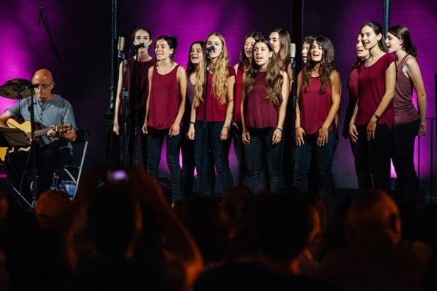 El Cor de Noies durant l'actuació musical amb el director, Jaume Sala _617x412
