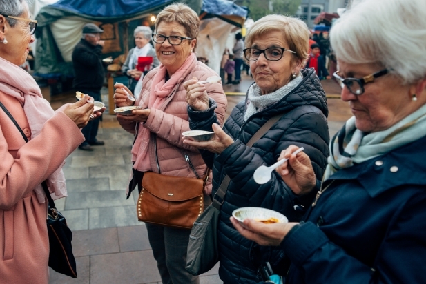 Un grup de dones conversa mentre tasten la crema de Sant Josep / Q. Pascual