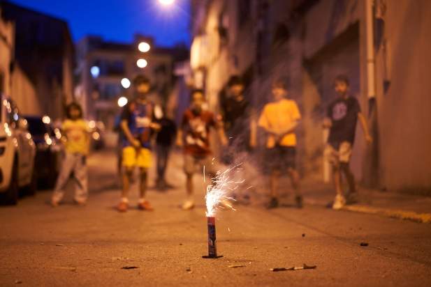 Uns nens juguen amb petards als carrers de Castellar durant la revetlla de Sant Joan 