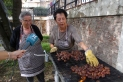 Dues voluntàries torrant castanyes al jardí de la Casa Massaveu / Carles Díaz