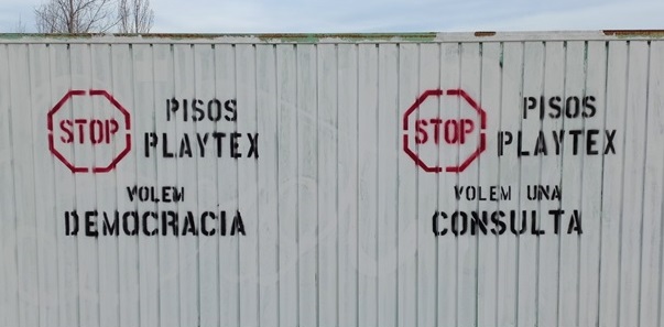 Tanca del solar de la Playtex amb pintades contràries als pisos de lloguer protegit. || Cedida