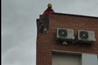 Els bombers revisant l'estat de la façana i la cornisa de l'edifici del carrer Tarragona