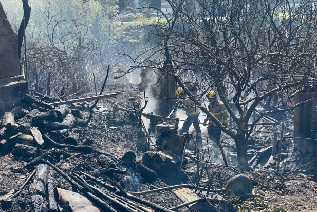 Bombers treballant en una de les zones cremades pel foc que s'ha produït a la zona d'horts de Can Carner