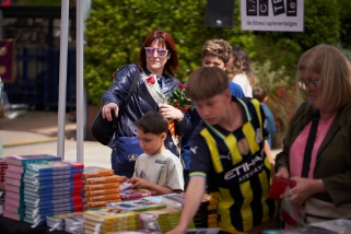 Petits i grans mirant i regirant llibres a una de les parades de llibres de la Fira de Sant Jordi que es van instal·lar a la plaça d’El Mirador