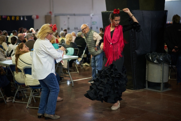 Dues dones ballen sevillanes al recinte firal durant la celebració de la Feria de Abril.