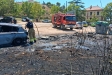 Els bombers apagant el foc del vehicle al costat de les restes de contenidors